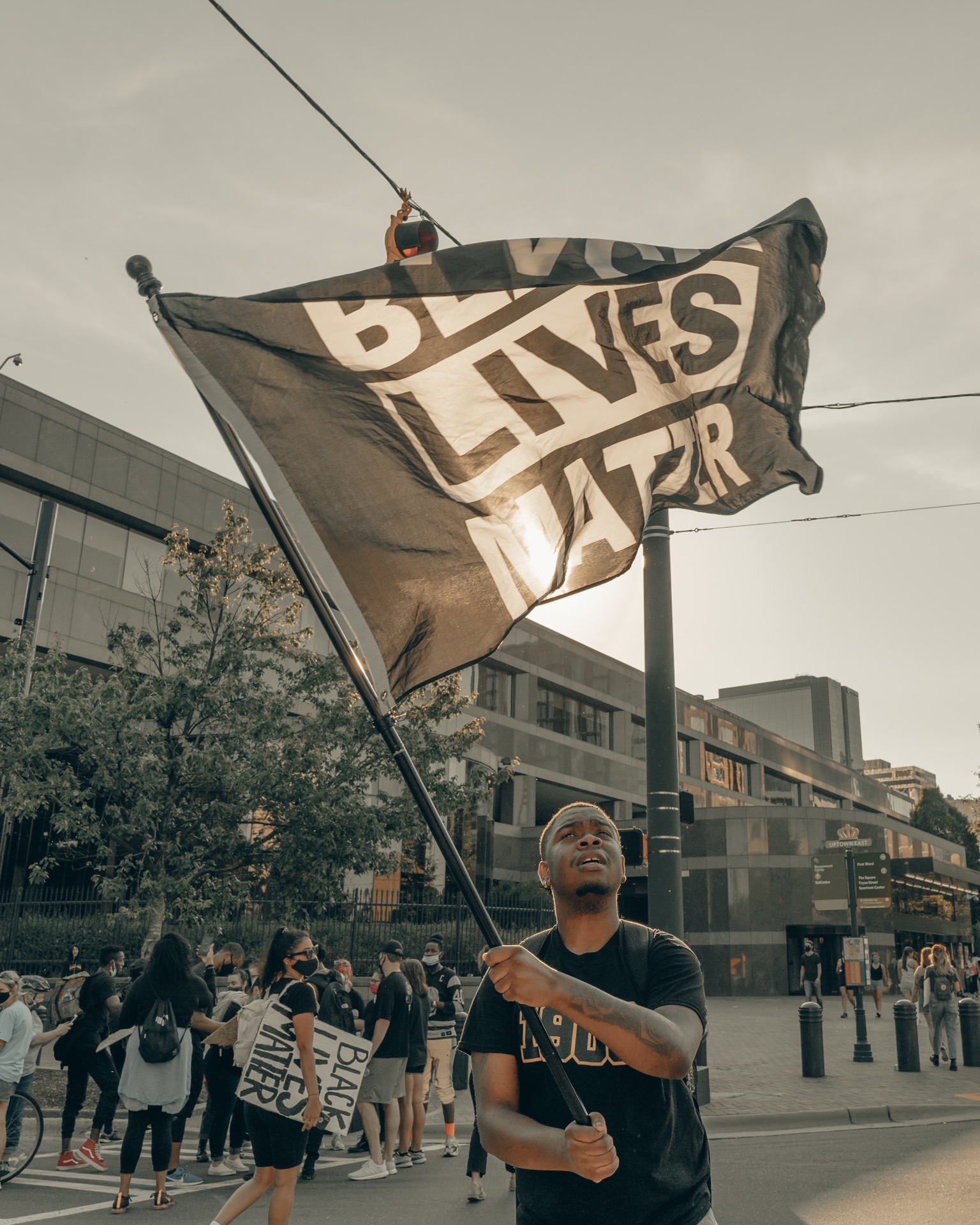 Manifestante portando bandera con el lema "Black Lives Matter"